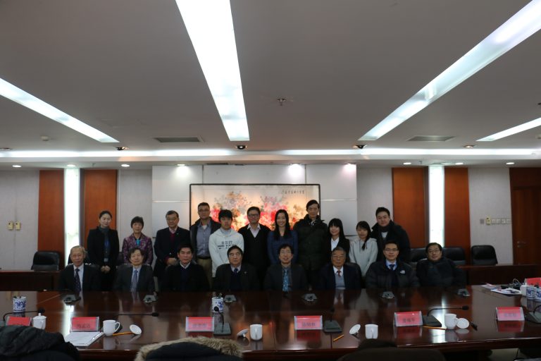 Group photo of professionals at a conference table with nameplates and microphones.