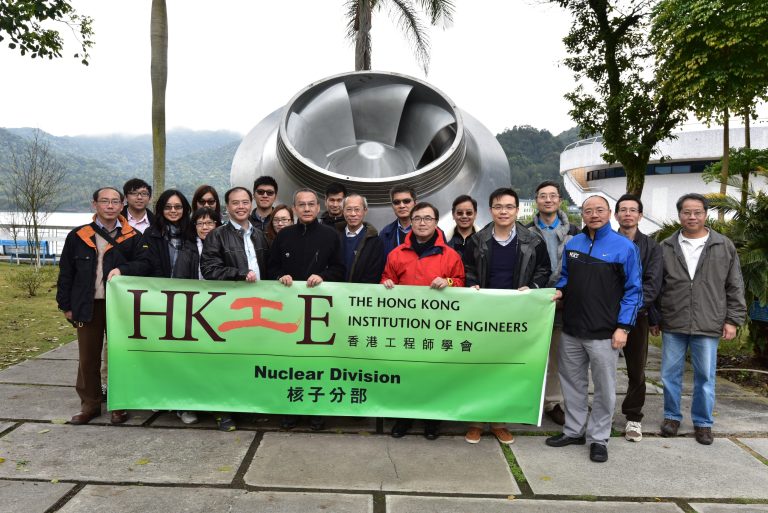 Group of engineers holding HKIE Nuclear Division banner in front of a large turbine.