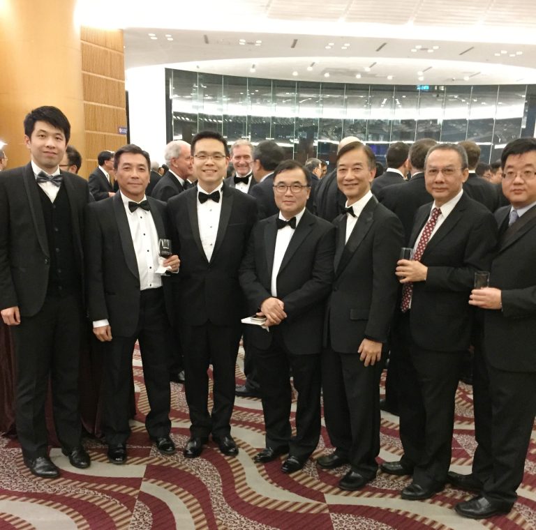 Group of men in formal attire posing for photo at event