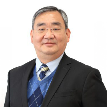 Portrait of a man wearing glasses, a suit, and a patterned tie.