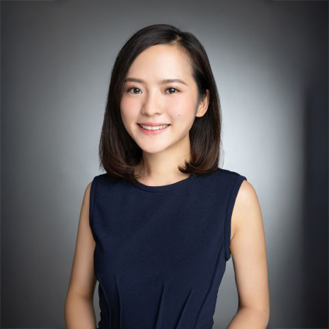 Professional headshot of a smiling woman with shoulder-length dark hair wearing a navy sleeveless top.