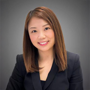 Professional headshot of a smiling woman with shoulder-length brown hair wearing a dark blazer.