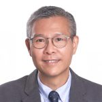 Smiling man with glasses wearing a suit and tie