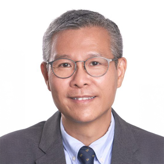 Headshot of a smiling man with glasses, wearing a suit and tie.
