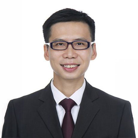 Portrait of a smiling man wearing glasses, suit, and tie.