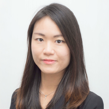 Portrait of a woman with long dark hair wearing a black top and necklace.