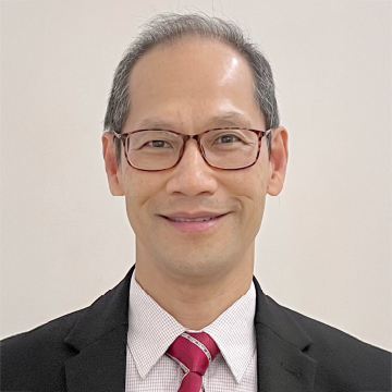 Headshot of a smiling man with glasses wearing a suit and red tie