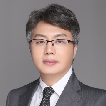 Professional headshot of a man with glasses wearing a suit and tie