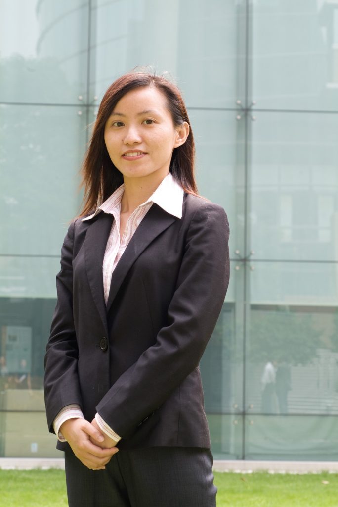Businesswoman in suit standing outdoors in front of glass building