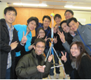 Group of people posing with a model rocket in a classroom setting