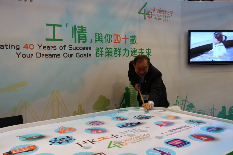 Man interacting with interactive display celebrating HKIE's 40th anniversary.