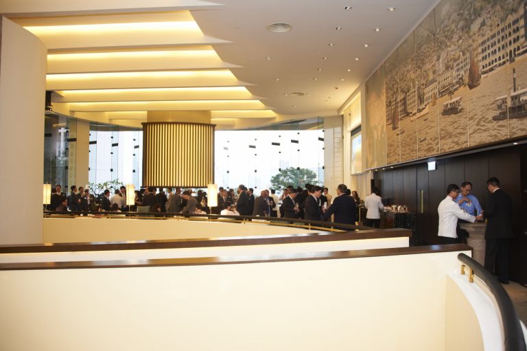 People networking in a modern hotel lobby with large murals and warm lighting.