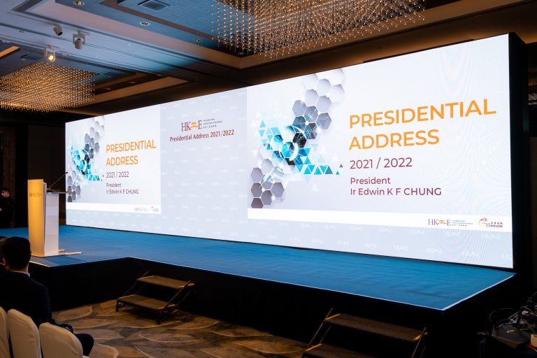 Presidential Address 2021/2022 event stage with speaker podium and large screen display.