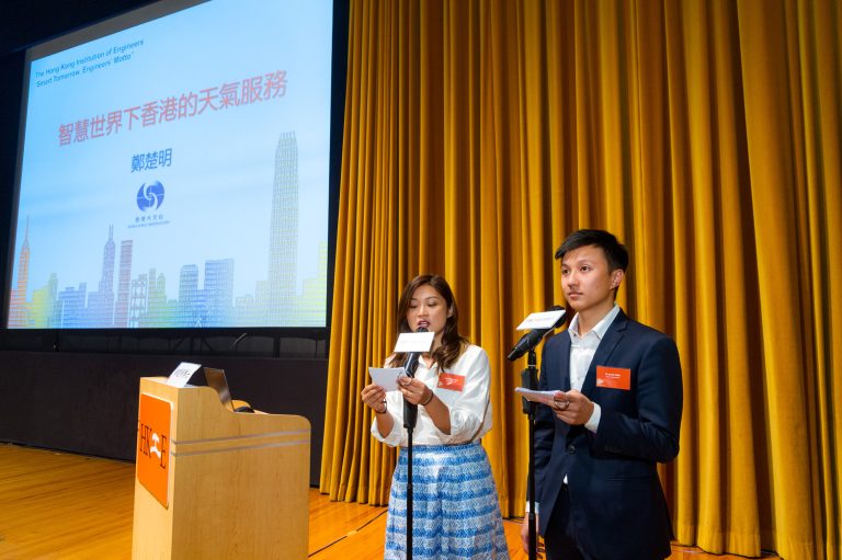 Two speakers present at an event with a large screen displaying a presentation about Hong Kong's weather services.