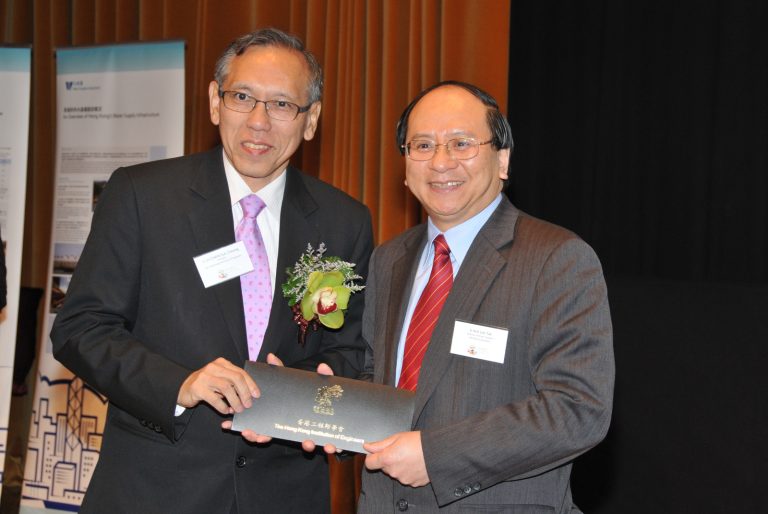 Two men in suits exchanging a certificate from The Hong Kong Institution of Engineers.