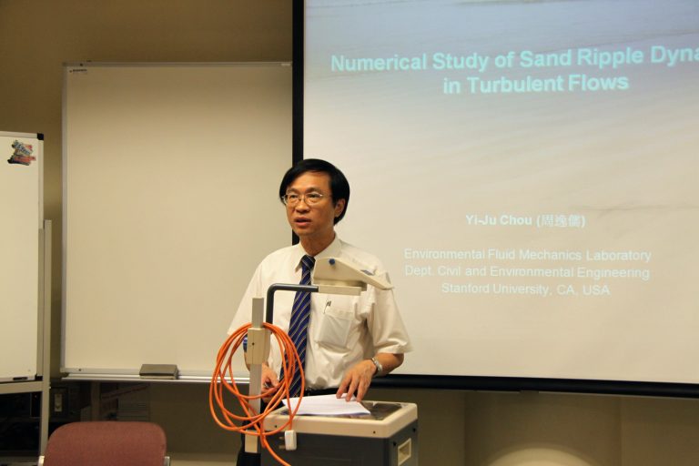 Man presenting at Stanford University on sand ripple dynamics in turbulent flows.