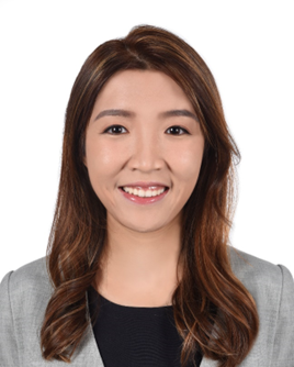 Professional headshot of a smiling woman with brown hair wearing a gray blazer.
