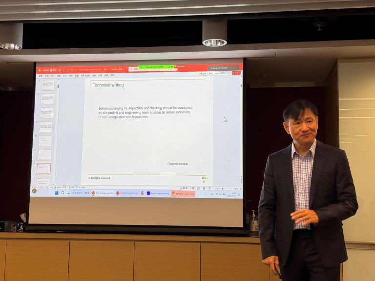 Man presenting a slide on technical writing in a conference room.