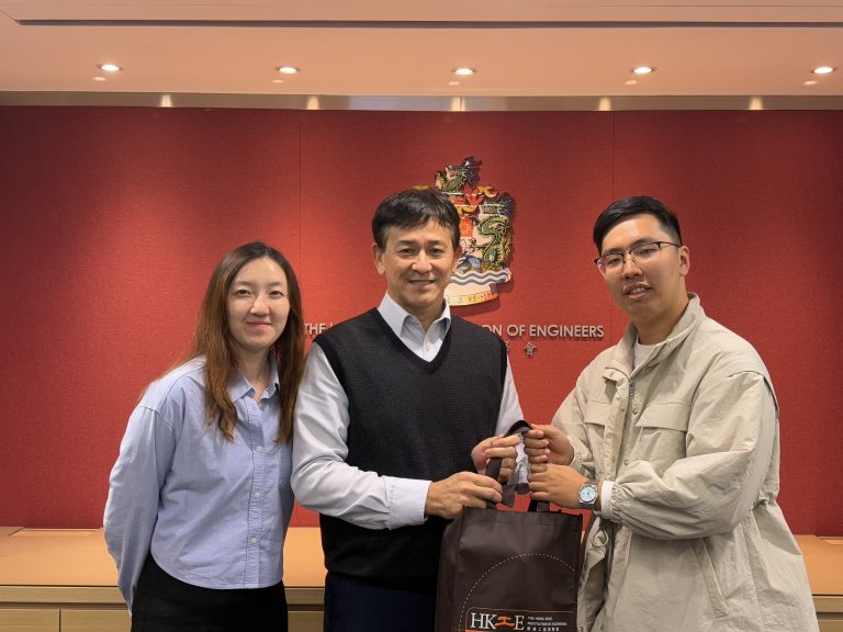 Three people posing for a photo in front of The Hong Kong Institution of Engineers logo.