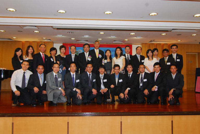 Group photo of professionals in formal attire posing for a corporate event.
